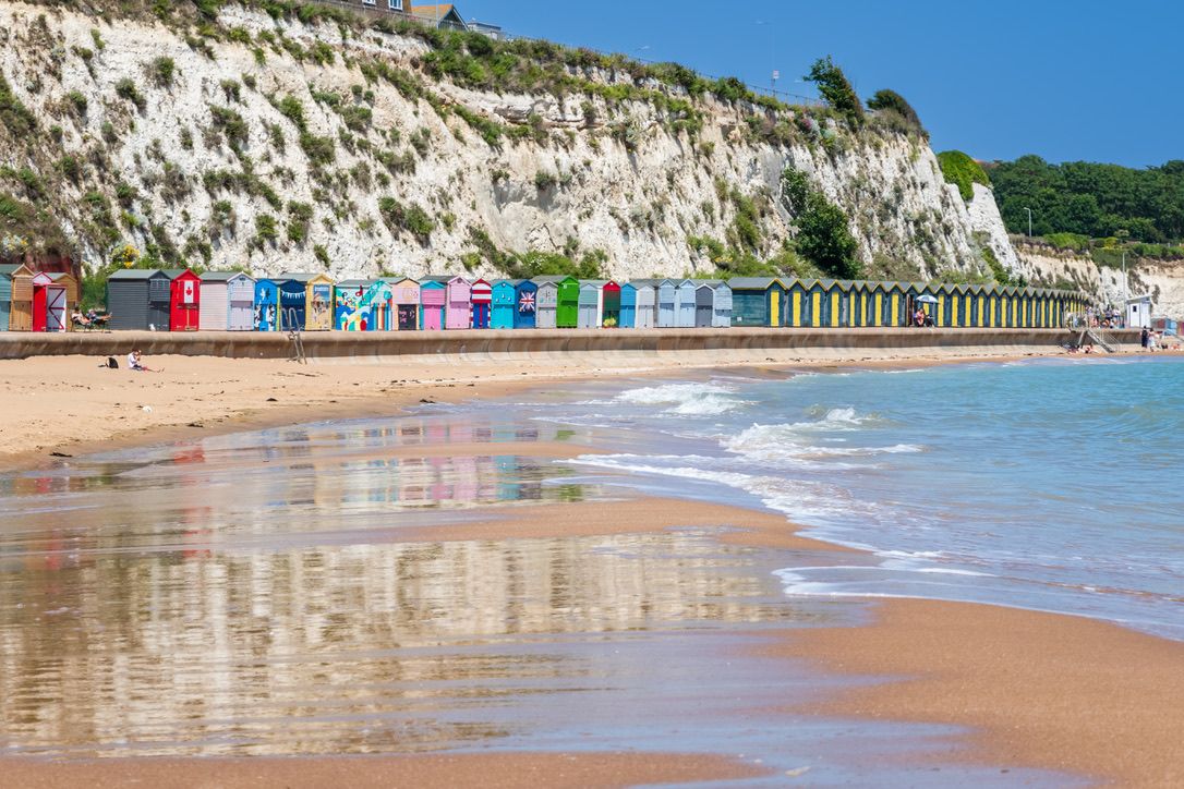 Kent, England - 14 June, 2022 - Beach huts and the sandy beach at Stone Bay in the seaside town of Broadstairs